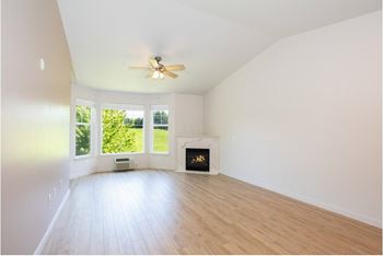 Vacant room with fireplace and ceiling fan